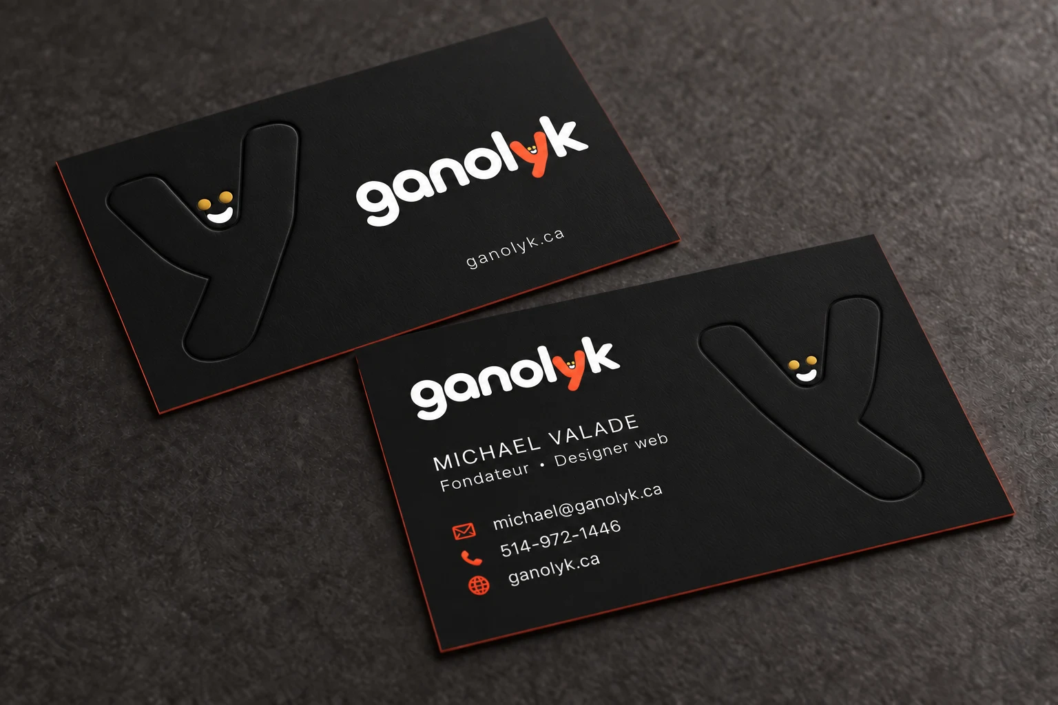 Cartes d’affaires ganolyk noires aux tranches corail, avec le y en relief et les coordonnées de Michael.